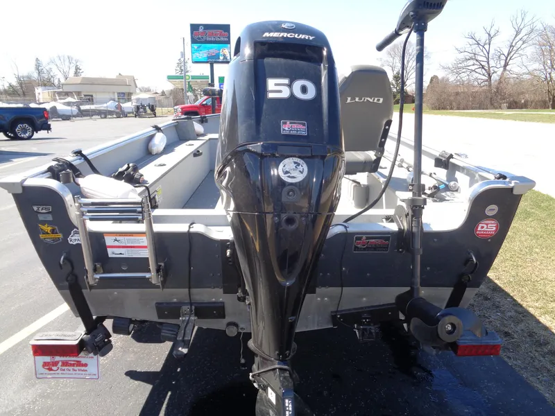 Slide: The Image of 2023 Lund 1600 Alaskan Tiller boat with Mercury 50 HP outboard motor, parked outdoors. - 13
