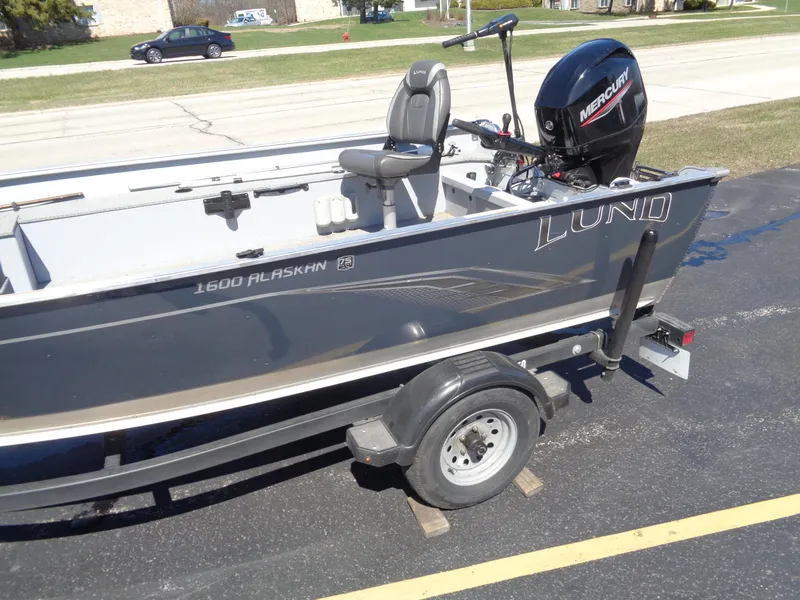 Slide: The Image of 2023 Lund 1600 Alaskan Tiller boat on trailer with Mercury outboard motor. - 2