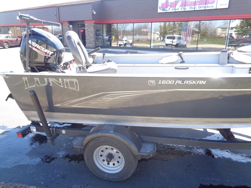 Slide: The Image of 2023 Lund 1600 Alaskan Tiller boat on trailer, featuring a Mercury outboard motor. - 5