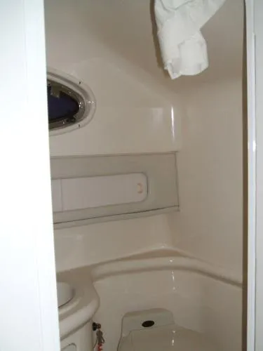 Slide: The Image of 1998 Sea Ray 270 Sundancer bathroom interior with compact design and porthole window. - 5