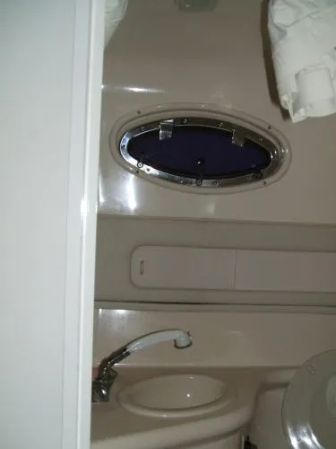 Slide: The Image of 1998 Sea Ray 270 Sundancer bathroom with sink, porthole, and toilet. - 6