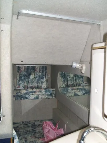 Slide: The Image of 1998 Sea Ray 270 Sundancer cabin interior with floral upholstery and compact design. - 7