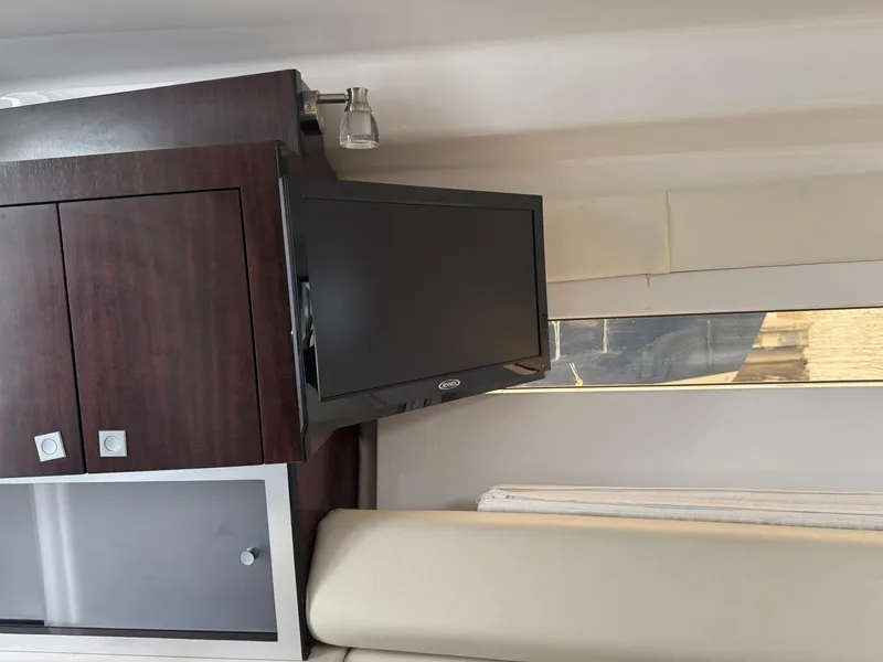 Slide: The Image of Interior of 2020 Monterey 295 Sport Yacht with mounted TV and wooden cabinetry. - 23