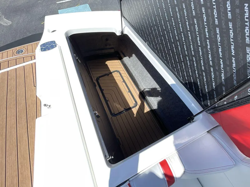 Slide: The Image of 2017 Nautique Super Air G23 storage compartment with open lid, showcasing spacious interior. - 17