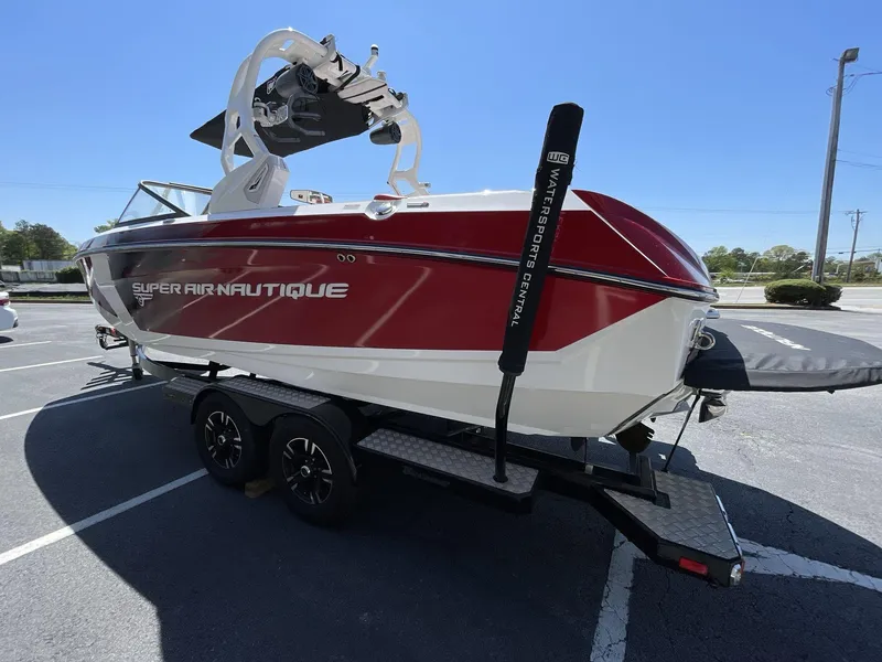 Slide: The Image of 2017 Nautique Super Air G23 boat on trailer, red and white design, parked outdoors. - 5