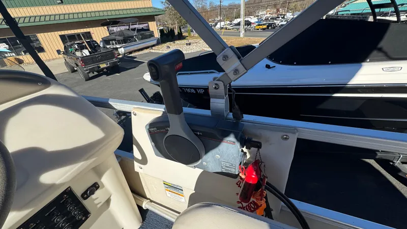 Slide: The Image of Control panel of a 2003 Godfrey Sweet Water boat, featuring throttle and steering mechanisms. - 10
