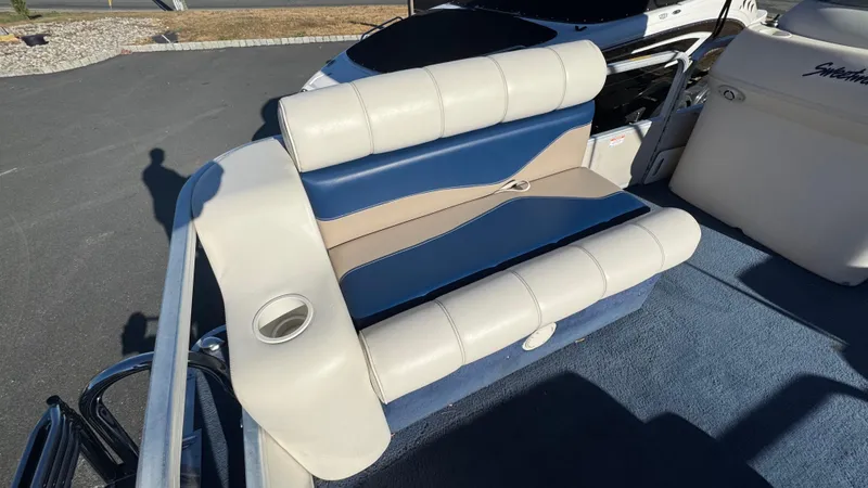 Slide: The Image of 2003 Godfrey Sweet Water boat seat with blue and beige upholstery, cup holder, and carpeted floor. - 11