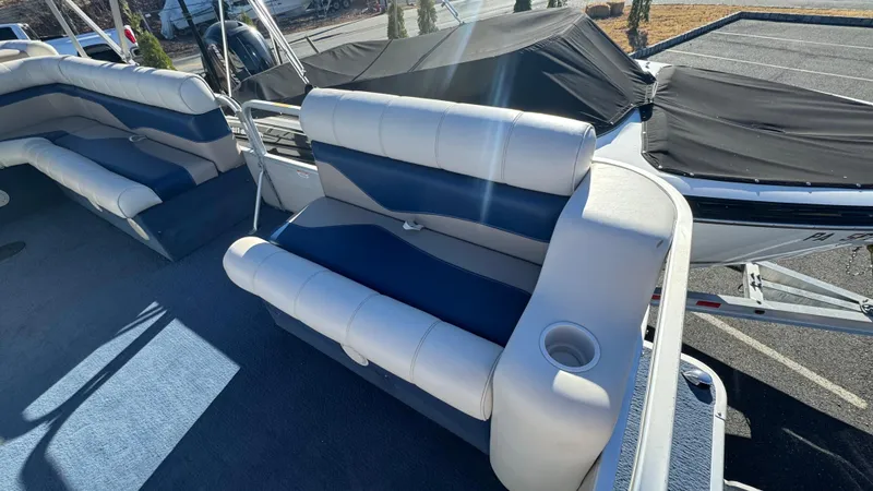 Slide: The Image of 2003 Godfrey Sweet Water boat interior with blue and white seating and cup holder. - 12