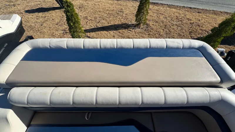 Slide: The Image of 2003 Godfrey Sweet Water boat seat with beige and blue upholstery, outdoors. - 13