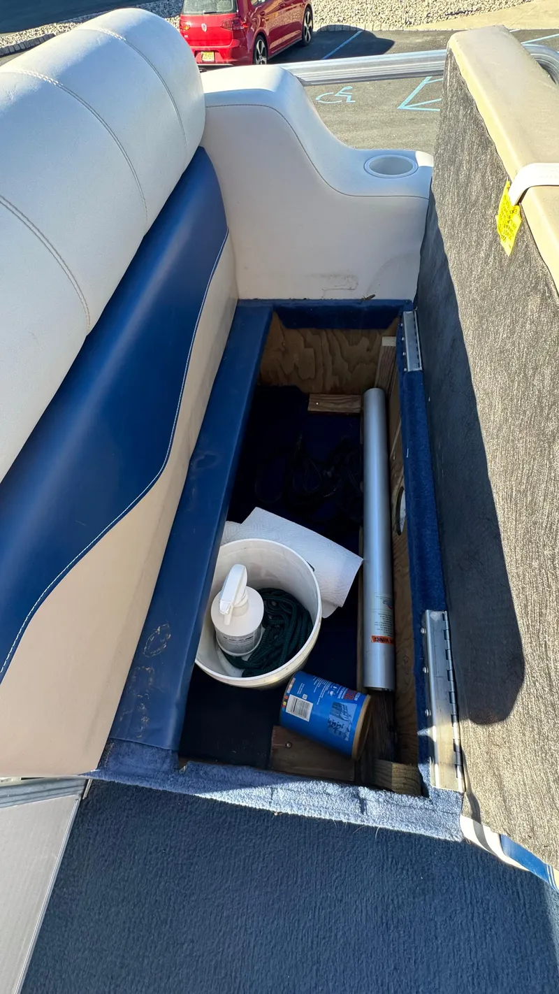 Slide: The Image of Storage compartment in a 2003 Godfrey Sweet Water boat with various items inside. - 17