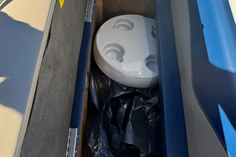 Slide: The Image of Storage compartment in a 2003 Godfrey Sweet Water boat with a round white object inside. - 19