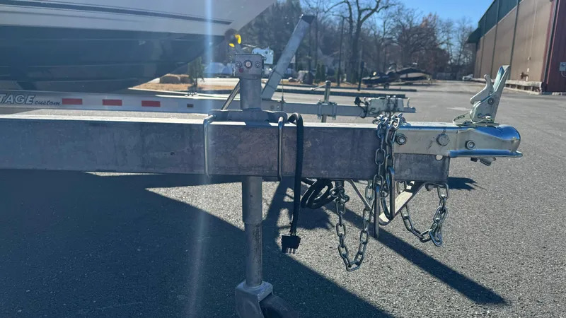 Slide: The Image of Trailer hitch of a 2003 Godfrey Sweet Water boat, parked on asphalt. - 26