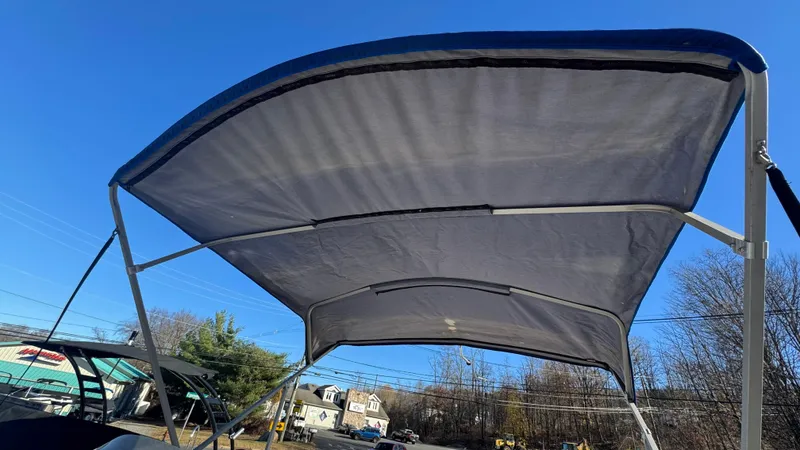 Slide: The Image of Bimini top of a 2003 Godfrey Sweet Water boat against a clear blue sky. - 3