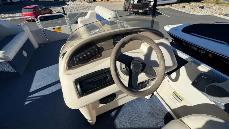 Slide: The Image of 2003 Godfrey Sweet Water boat dashboard with steering wheel and controls. - 8