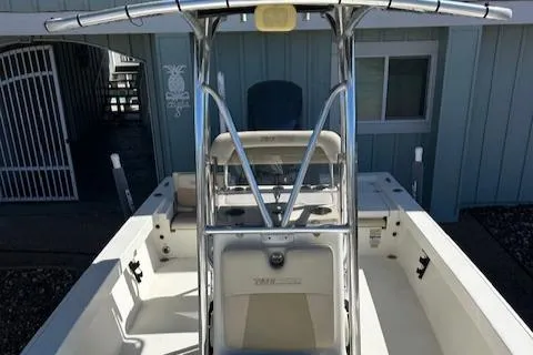 Slide: The Image of 2013 Pathfinder 2400 TRS boat with T-top and center console, docked near a building. - 4