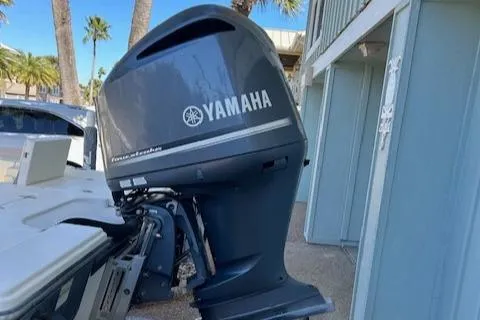 Slide: The Image of Yamaha outboard motor on 2013 Pathfinder 2400 TRS boat, parked near palm trees. - 6