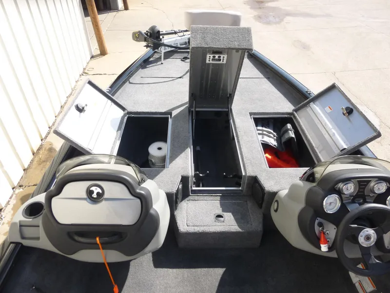 Slide: The Image of 2016 Tracker Pro Team 195 TXW boat interior with open storage compartments and control panels. - 14