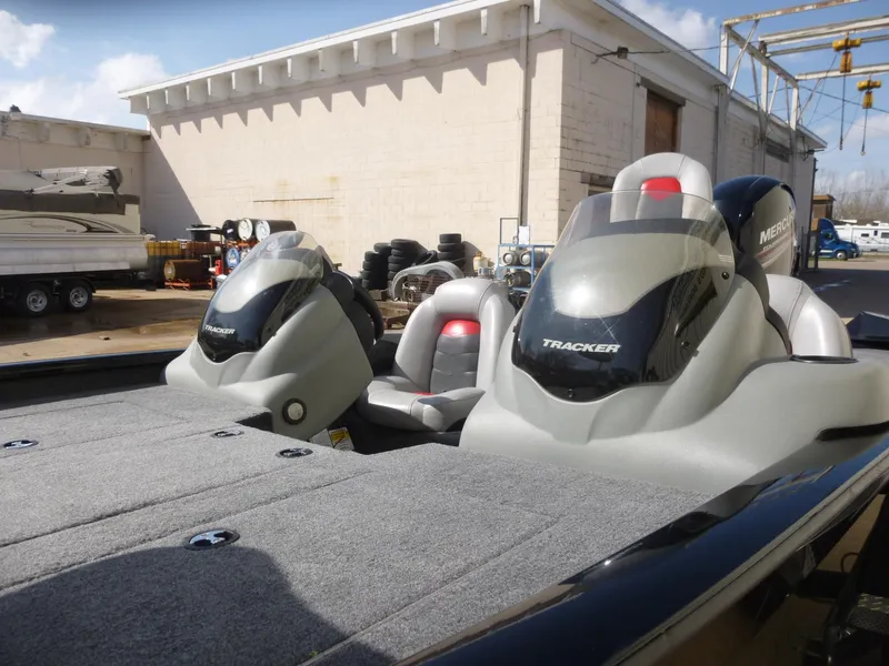 Slide: The Image of 2016 Tracker Pro Team 195 TXW boat with dual seats and Mercury engine, parked outdoors. - 21