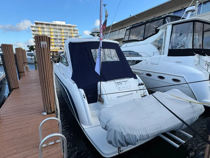 Slide: The Image of 2004 Formula 40 PC yacht docked at marina, covered dinghy attached, clear sky background. - 10
