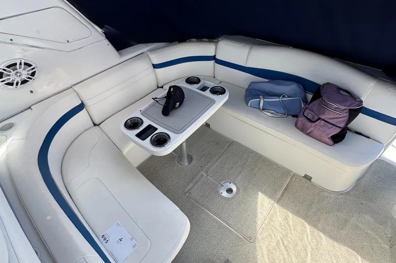 Slide: The Image of 2004 Formula 40 PC boat interior with white seating, table, and bags. - 18
