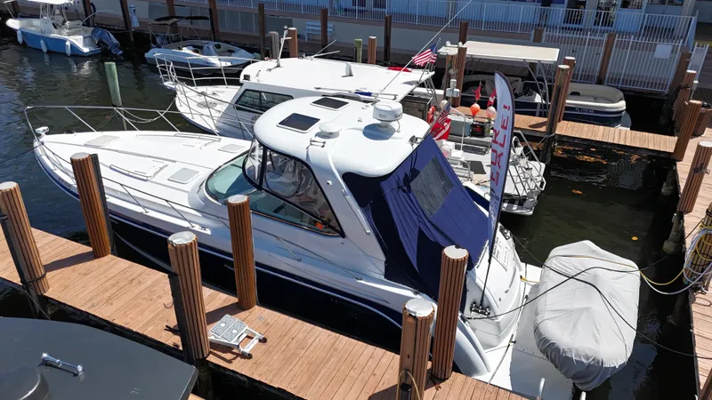 Slide: The Image of 2004 Formula 40 PC yacht docked at marina, featuring sleek design and covered seating area. - 3