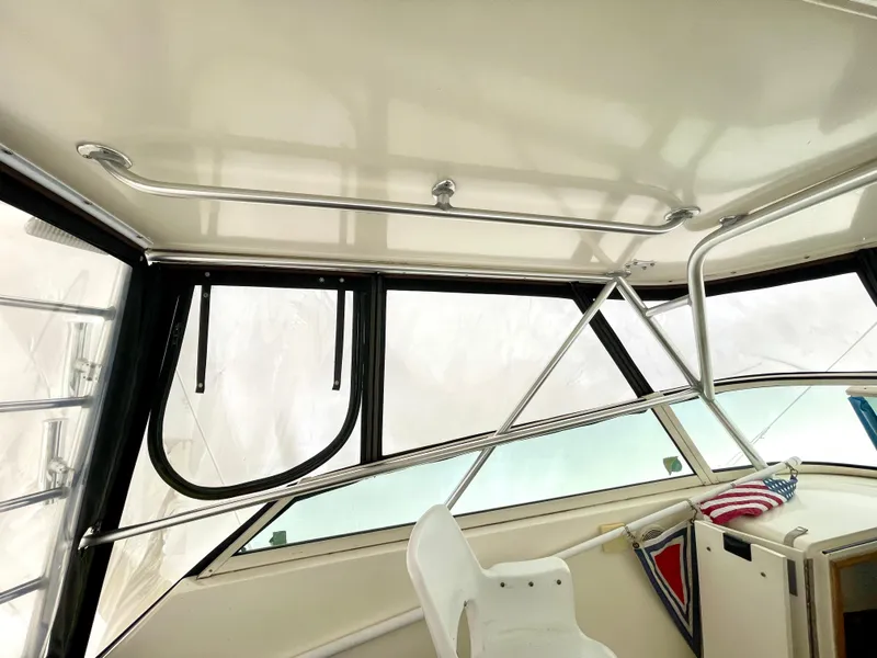 Slide: The Image of 1999 Henriques 28 Express Sportfish interior with helm, windows, and seating. - 11