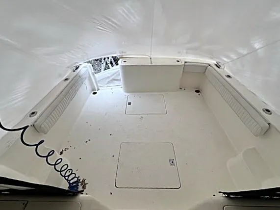 Slide: The Image of 1999 Henriques 28 Express Sportfish boat interior with white seating and storage compartments. - 12