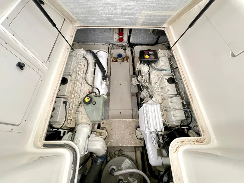 Slide: The Image of Engine compartment of a 1999 Henriques 28 Express Sportfish boat, showcasing dual engines. - 22