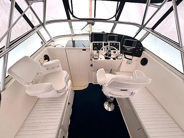 Slide: The Image of 1999 Henriques 28 Express Sportfish boat interior with helm, seating, and navigation equipment. - 4