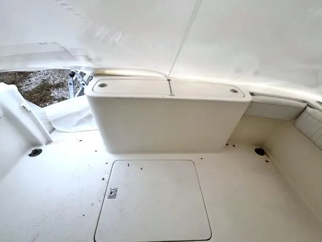 Slide: The Image of 1999 Henriques 28 Express Sportfish interior with white seating and storage compartment. - 13