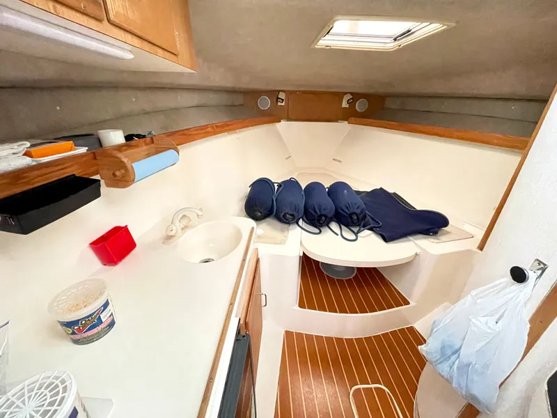 Slide: The Image of 1999 Henriques 28 Express Sportfish cabin interior with wooden flooring and storage space. - 15