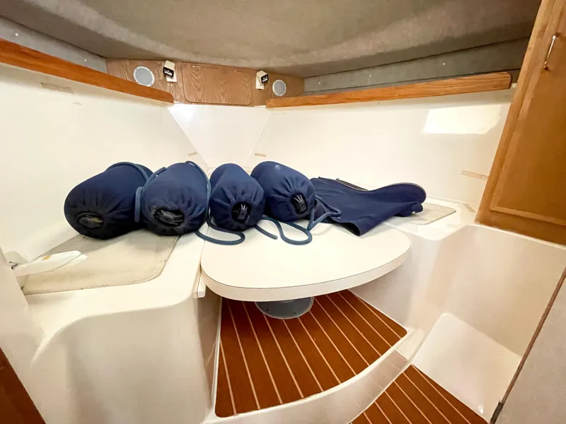 Slide: The Image of 1999 Henriques 28 Express Sportfish cabin interior with cushions and wooden accents. - 16