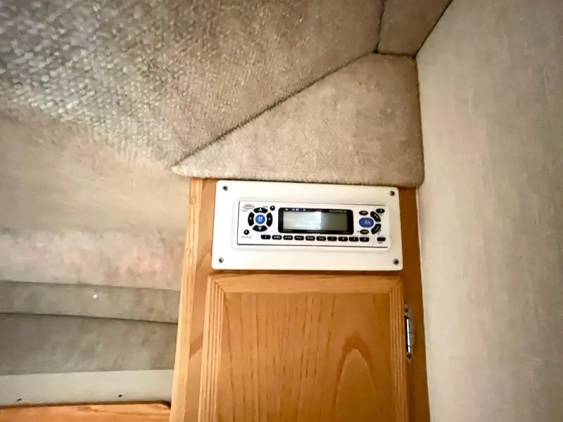 Slide: The Image of 1999 Henriques 28 Express Sportfish cabin interior with control panel above wooden cabinet. - 19