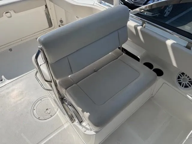 Slide: The Image of 2019 Boston Whaler 230 Vantage boat interior with cushioned seating and cup holders. - 6