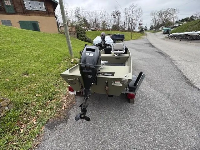 Slide: The Image of 2024 Tracker Grizzly 1436 Jon boat with motor on a paved road. - 9
