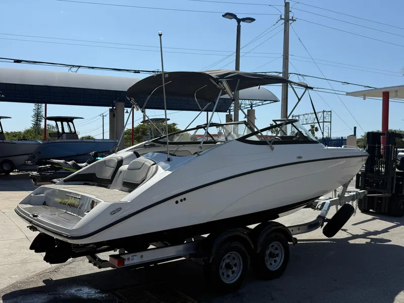 Slide: The Image of 2018 Yamaha Boats SX210 on trailer, parked outdoors under clear sky. - 10