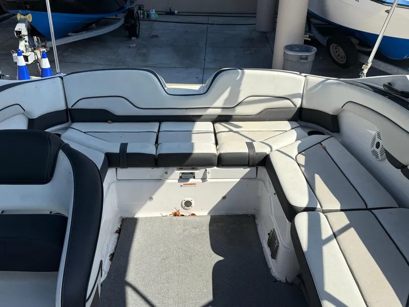 Slide: The Image of 2018 Yamaha Boats SX210 interior seating area with gray and black upholstery. - 12