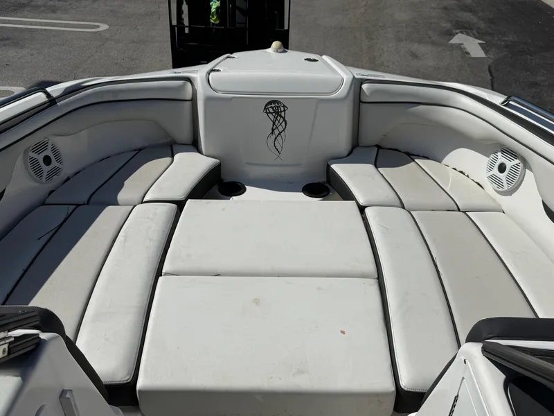 Slide: The Image of 2018 Yamaha Boats SX210 interior with white cushioned seating and speaker system. - 13