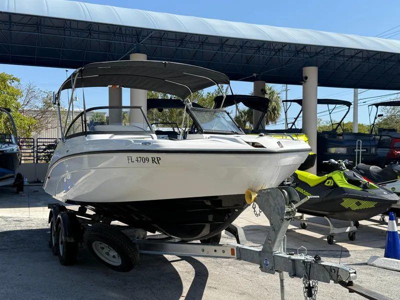 Slide: The Image of 2018 Yamaha Boats SX210 on trailer, parked outdoors under canopy. - 3
