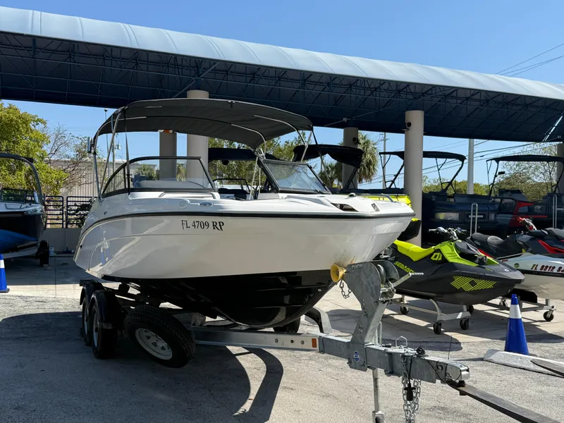 Slide: The Image of 2018 Yamaha Boats SX210 on trailer, parked outdoors under canopy. - 4