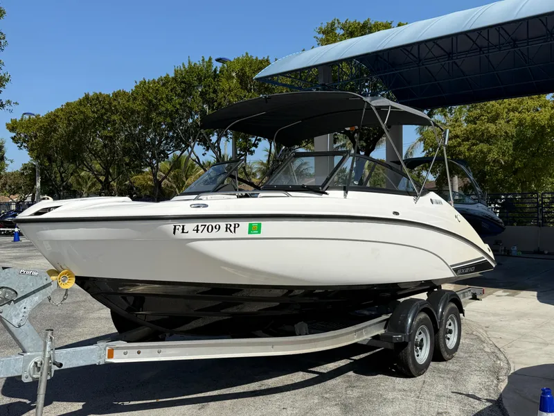 Slide: The Image of 2018 Yamaha Boats SX210 on trailer, parked outdoors under a canopy. - 6