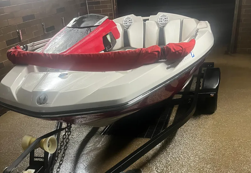Slide: The Image of 2015 Scarab 165 boat on trailer, white and red design, parked indoors. - 10