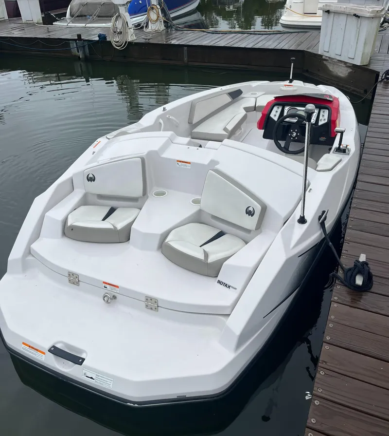 Slide: The Image of 2015 Scarab 165 boat docked, featuring sleek white design and comfortable seating. - 11