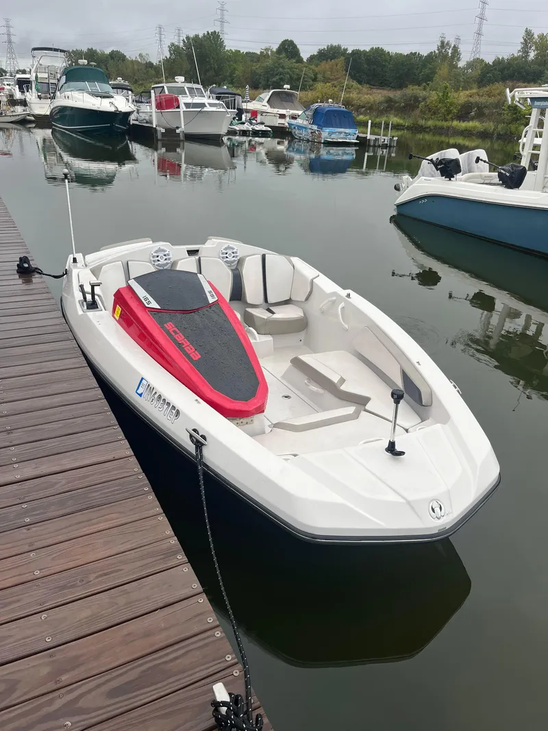 Slide: The Image of 2015 Scarab 165 boat docked at marina, surrounded by other vessels. - 7