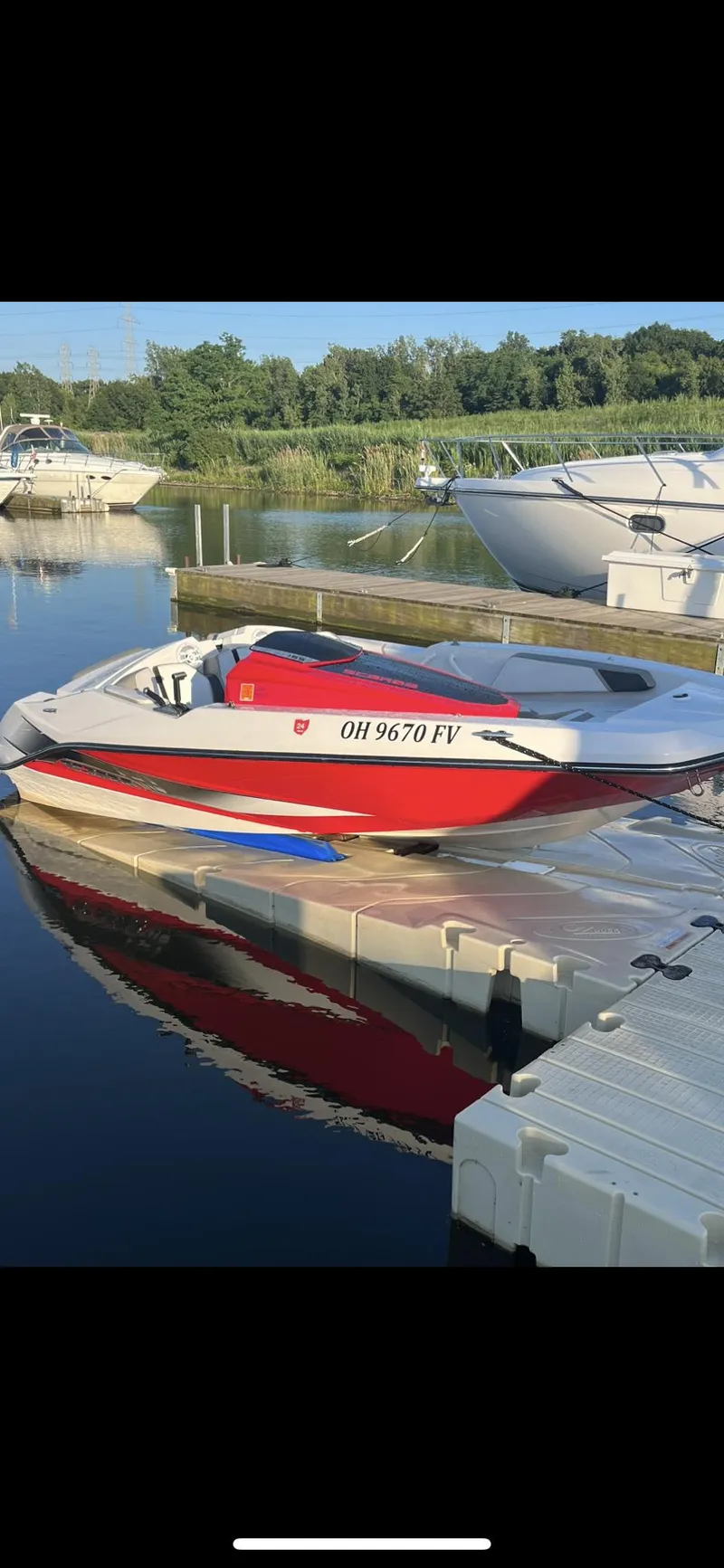 Slide: The Image of 2015 Scarab 165 boat docked on calm water with surrounding greenery. - 8