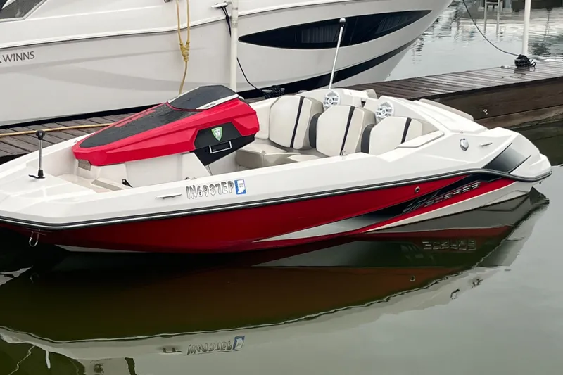 Slide: The Image of 2015 Scarab 165 boat with red and white design docked on calm water. - 9