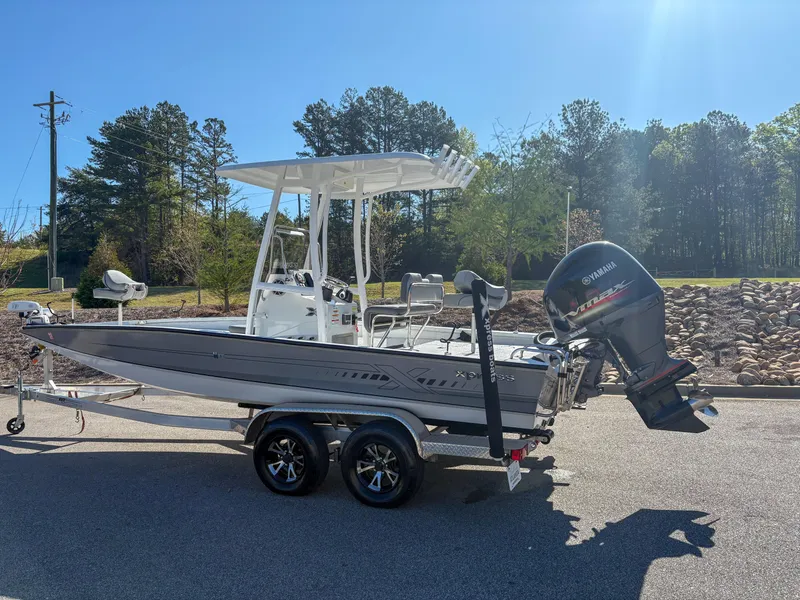 Slide: The Image of 2023 Xpress H22 boat on trailer with Yamaha outboard motor, parked outdoors. - 1