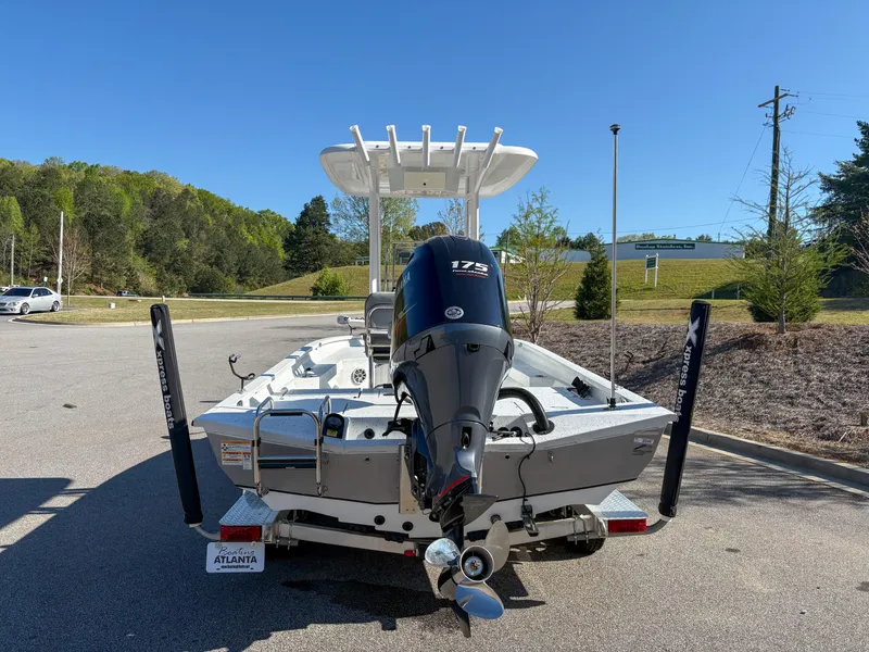 Slide: The Image of 2023 Xpress H22 boat with 175 HP engine, parked outdoors on a sunny day. - 2