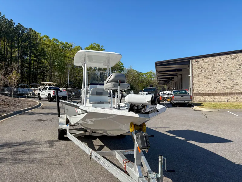 Slide: The Image of 2023 Xpress H22 boat on trailer in parking lot, surrounded by trees and vehicles. - 5