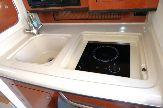 Slide: The Image of 2005 Sea Ray 280 Sundancer galley with sink and electric cooktop. - 15